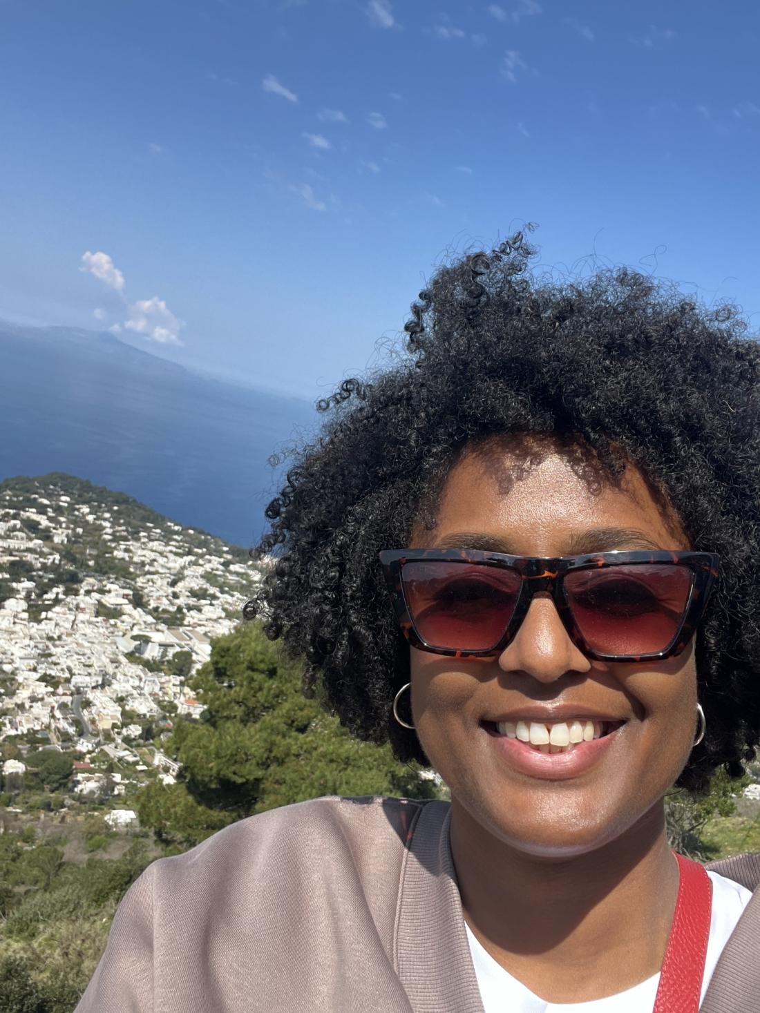 Black woman smiling in front a blue sky