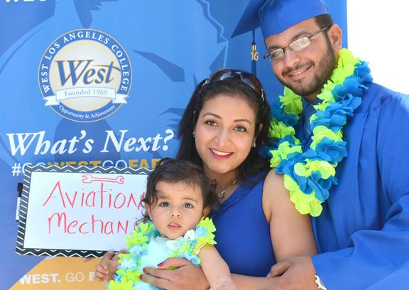 Male graduate with his wife and young child